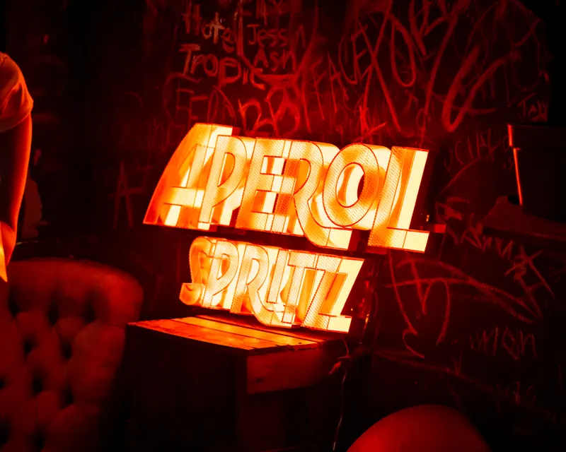 Illuminated Aperol Spritz sign inside a venue