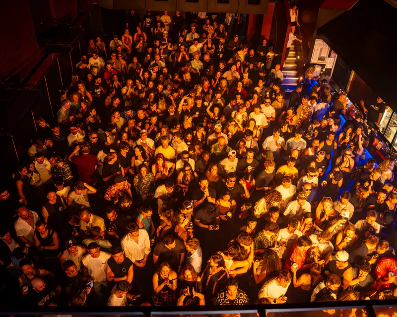 Overhead view of a packed venue under warm lighting