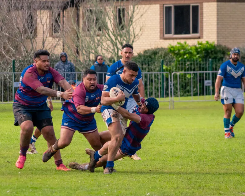 Rugby league ball carrier driving through two defenders